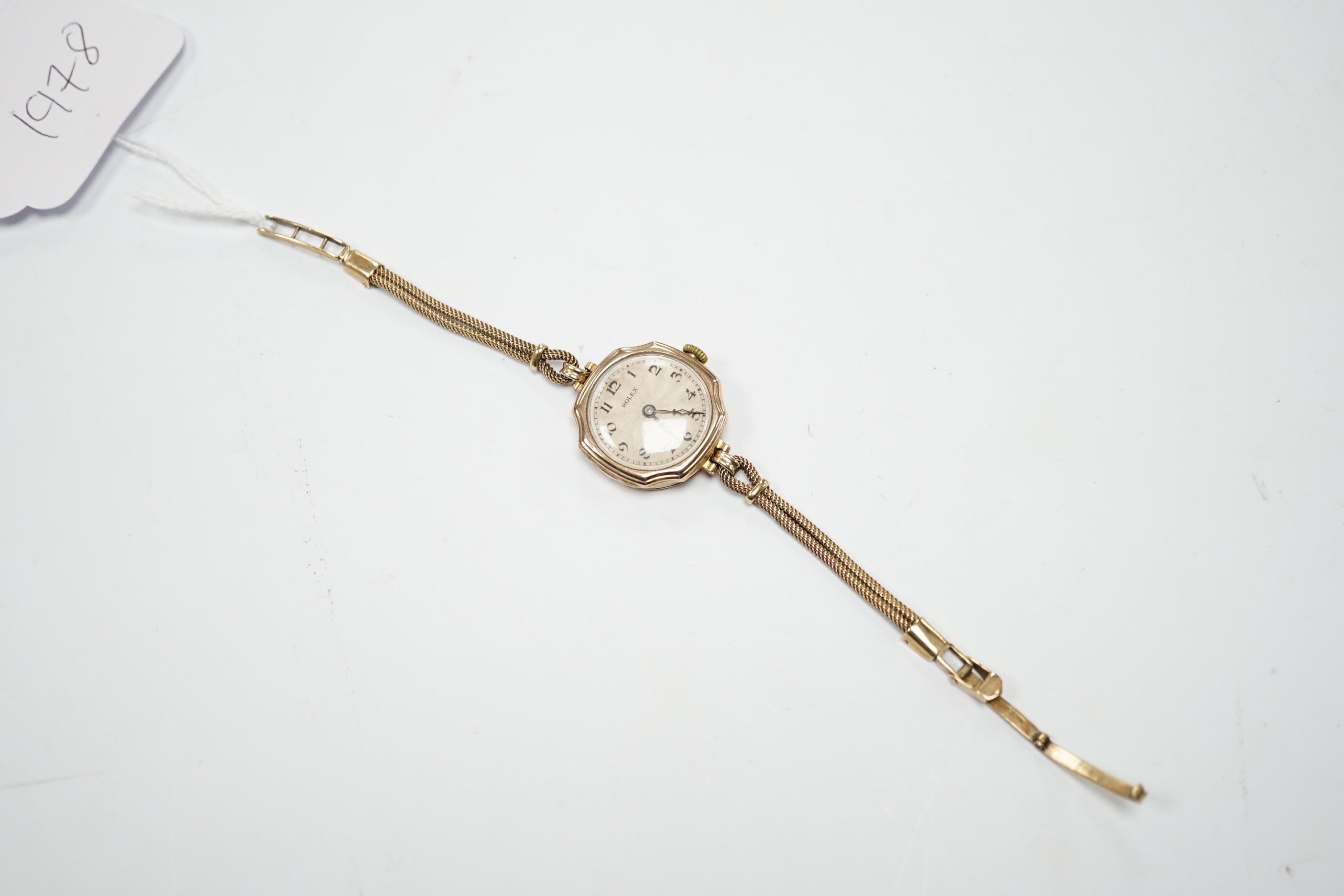 A lady's 1920's 9ct gold Rolex manual wind wrist watch, with sunburst Arabic dial, on a 9ct twin strand Vertex bracelet, gross weight 18.8 grams.